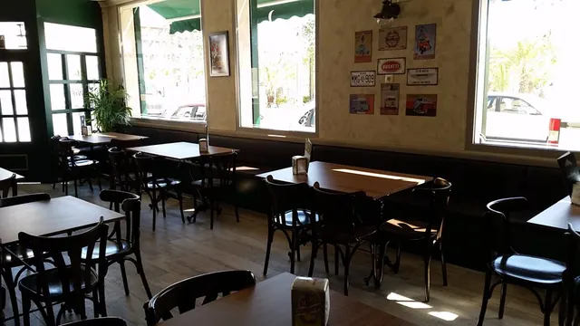 Interior de la cafetería con mesas de madera y paredes claras