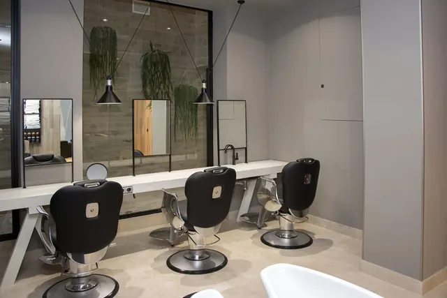 Puestos de peluquería con tocador lacado y sillones negros