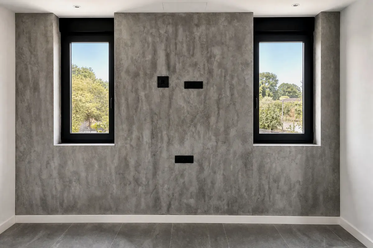 Pared de microcemento MicroStone efecto hormigón entre dos ventanas