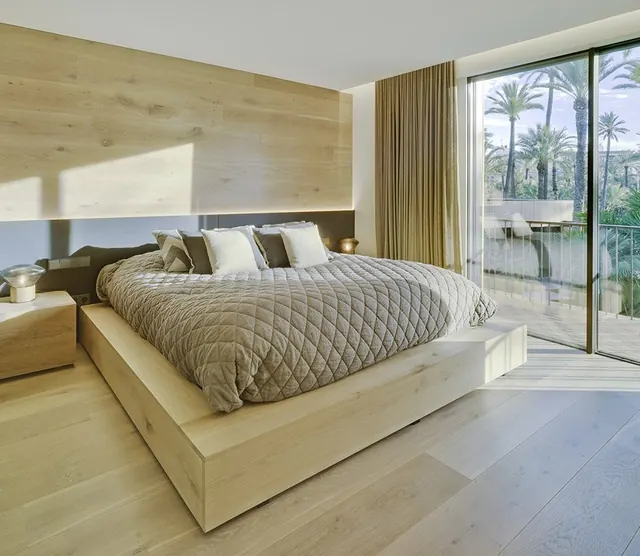 Dormitorio con cabecero de madera y ventanal al jardín