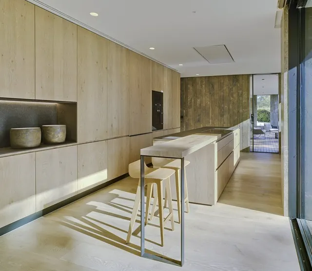 Cocina con mobiliario de madera y paneles lacados